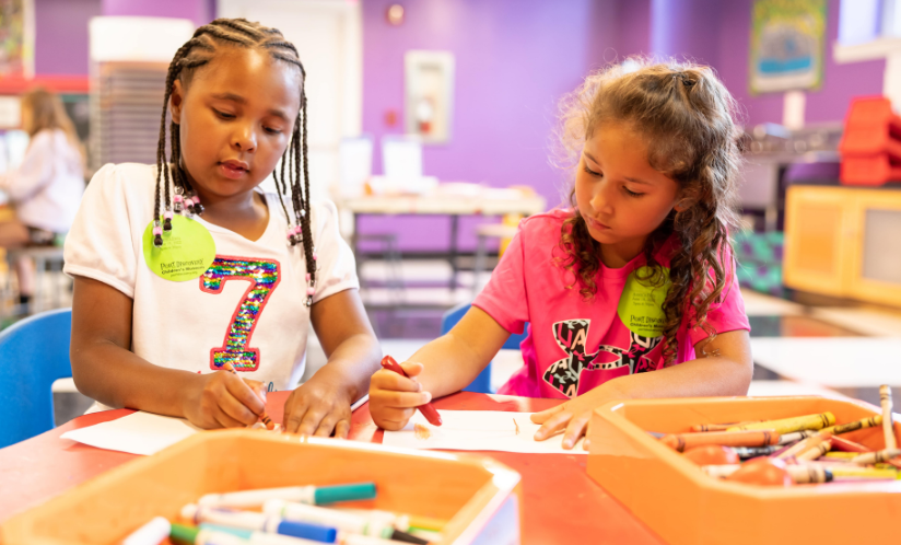 Two children work together on an art project at Port Discovery