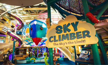 Sign that reads Sky Climber, The Sky's the Limit! in front of colorful, interactive play areas including a giant ship and multi-story slide