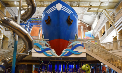 A front view of Port Discovery's multi-story Port Exhibit, which features a giant blue ship called the S.S. Friendship