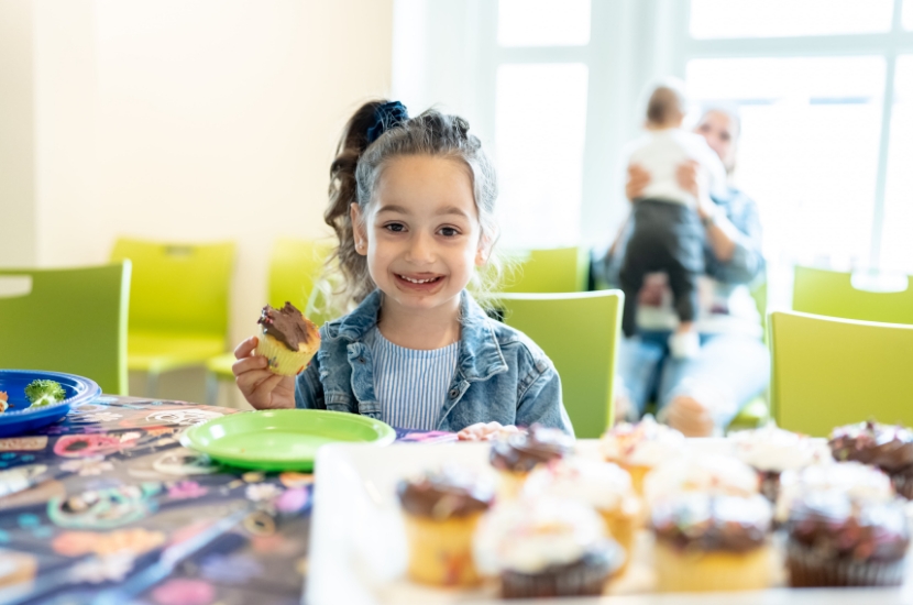 A child attending a birthday party at Port Discovery and enjoying cupcakes