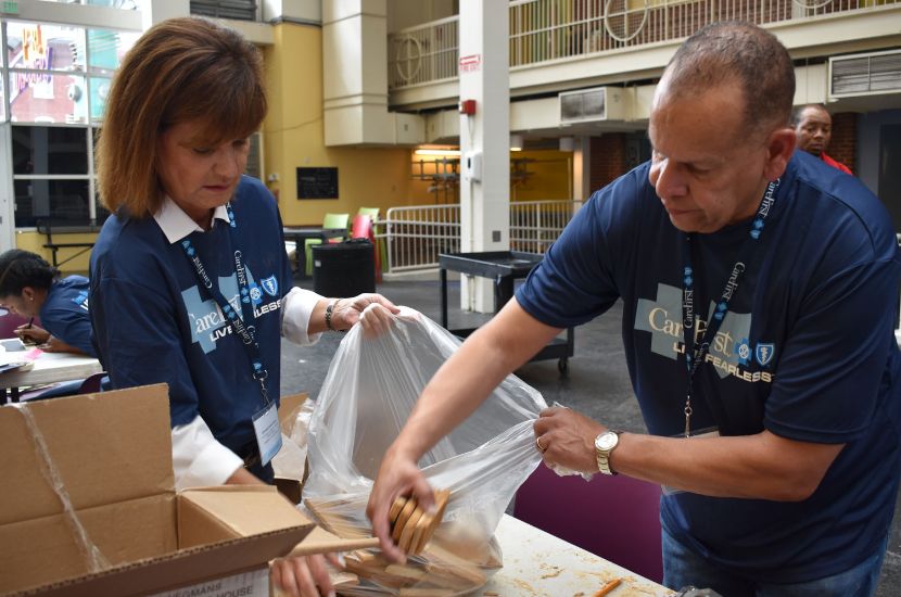 Two volunteers help out with a packing and sorting project at Port Discovery