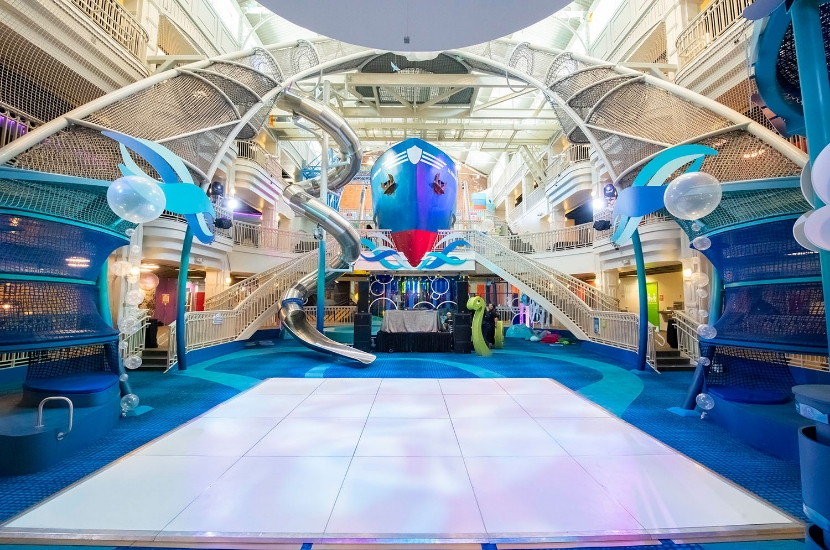 A large dance floor setup for a private event that features Port Discovery's bright, playful multi-story exhibits as the backdrop