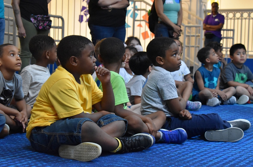 A group of children watching a performance as they enjoy a trip to Port Discovery Children's Museum