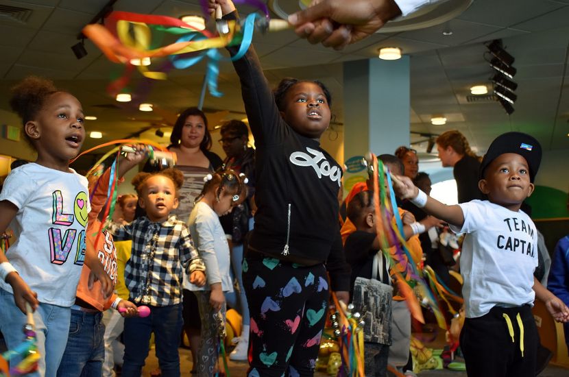 A group of children holding streamers and playing during an interactive program for kids at Port Discovery