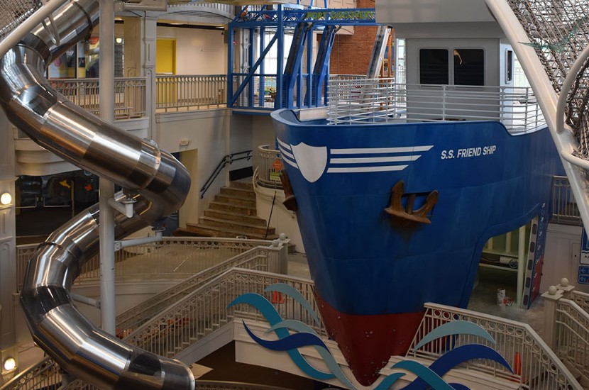 A view from above of Port Discovery's giant multi-story ship, the S.S. Friendship,, and a tall, swirly, metal slide.
