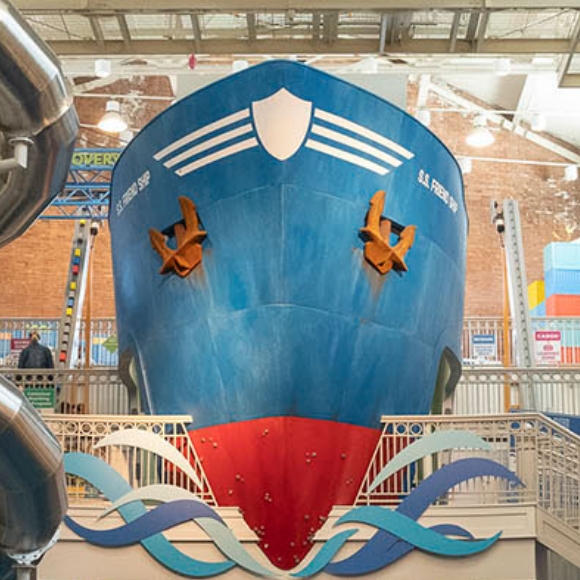 A giant blue ship featuring a red bottom and the name S.S. Friendship juts out from the back wall of Port Discovery Children's Museum