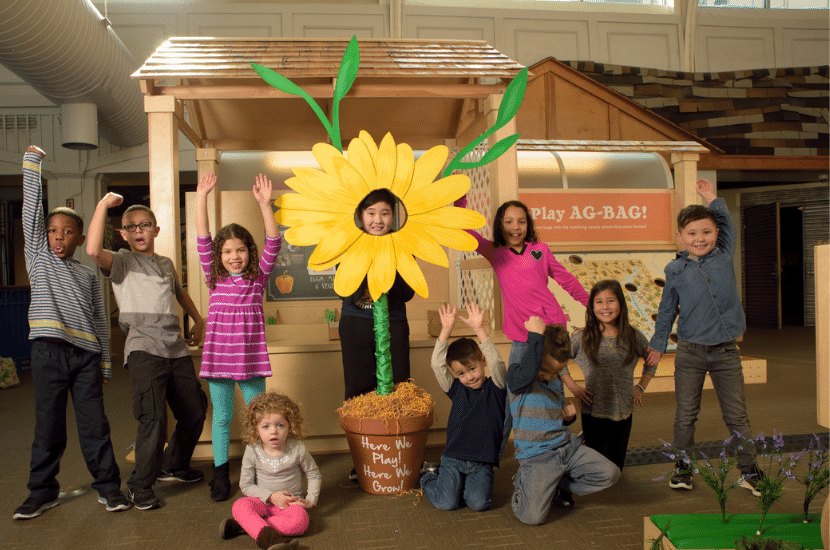 Kids smiling and happy in the Here We Grow Exhibit at Port Discovery Children's Museum