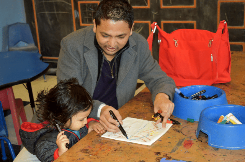 Man and girl work on a drawing in Port Discovery Children's Museum