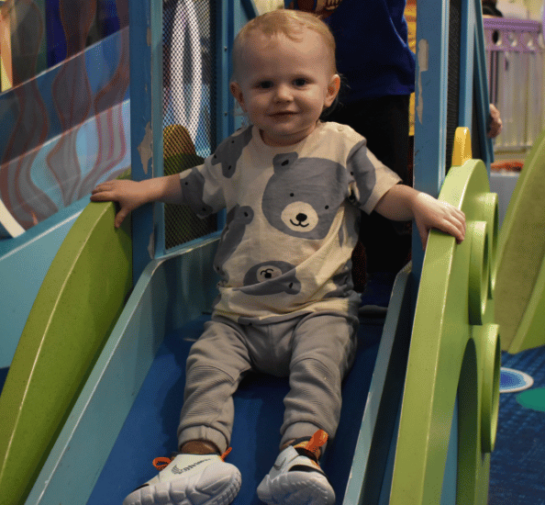 Toddler slides down the slide in Chessie's Grotto at Port Discovery Children's Museum