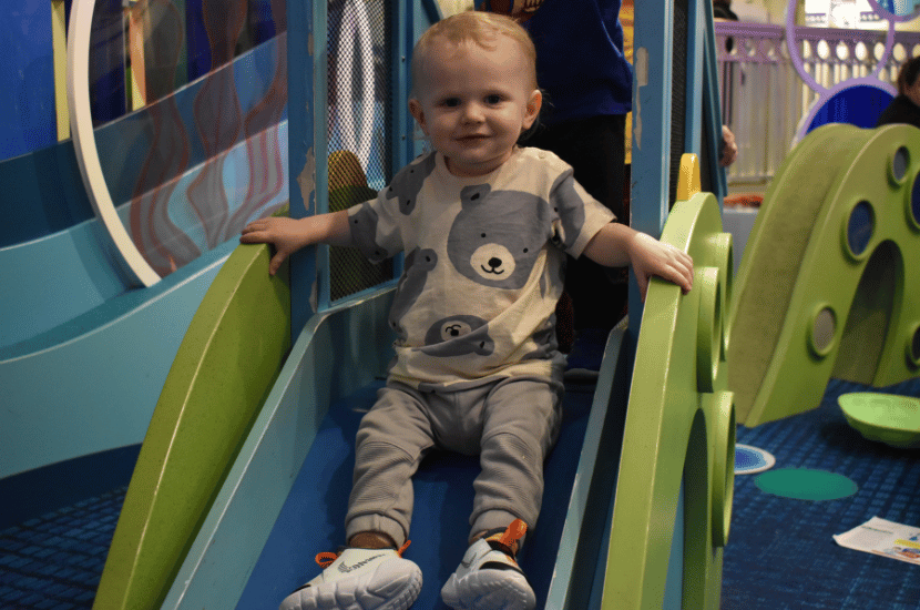 Toddler slides down the slide in Chessie's Grotto at Port Discovery Children's Museum
