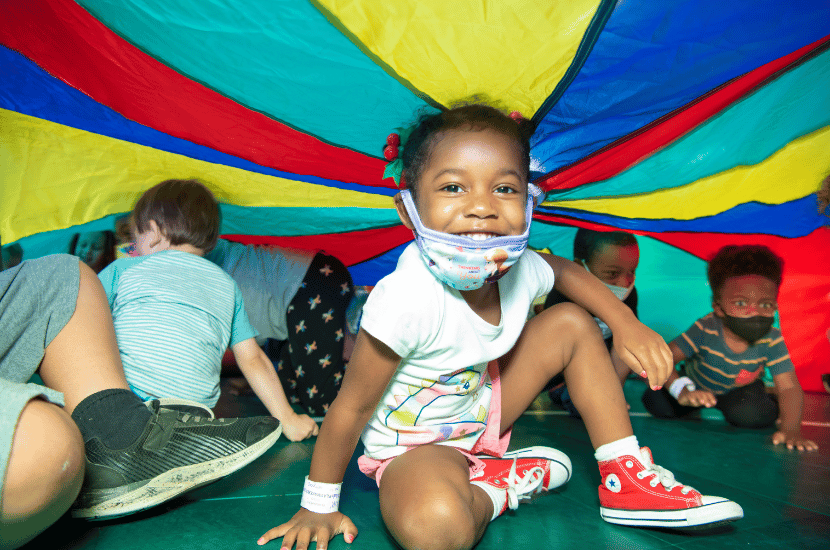 children play a parachute game at Port Discovery Children's Museum