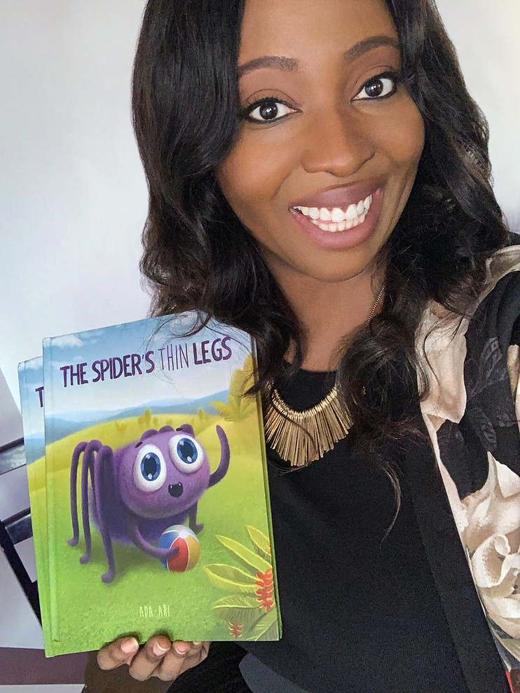 black author holding a book called "The Spider's Thin Legs".