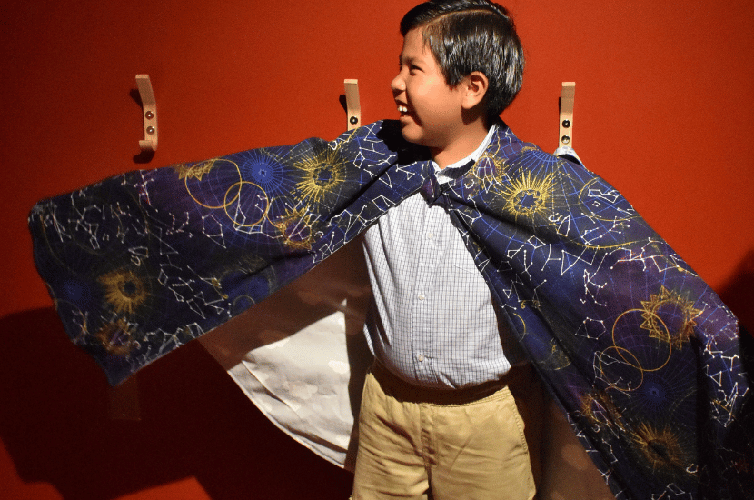 A boy poses in The Playhouse at Port Discovery, wearing a magicians costume
