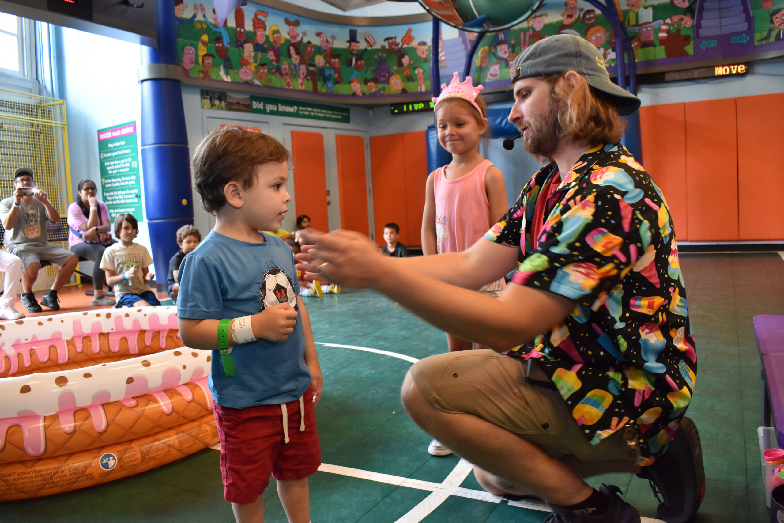 a staff member explaining a game to two children