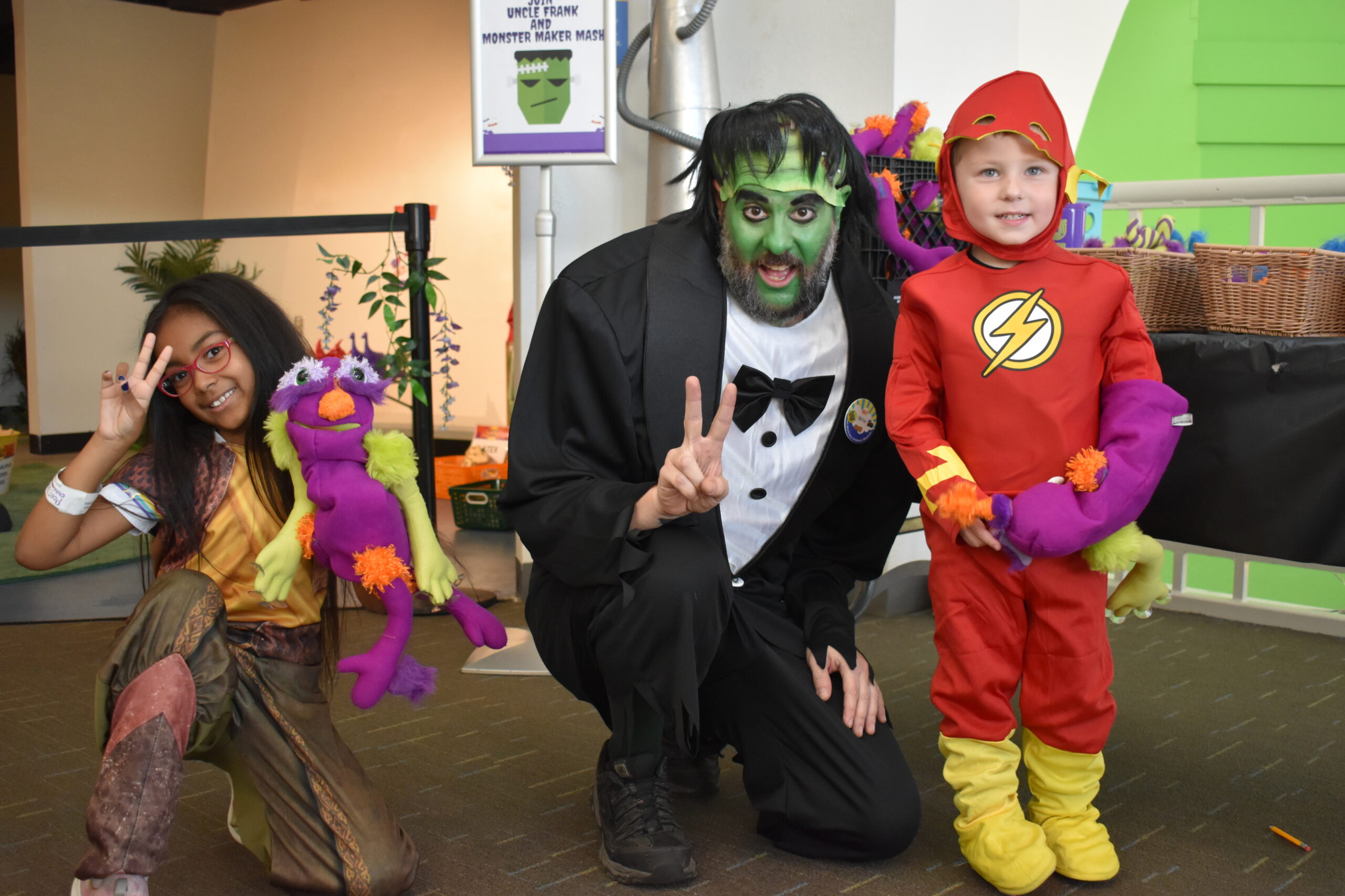 Group shot with two kids dressed in costumes with a staff member dressed as Frnakenstein