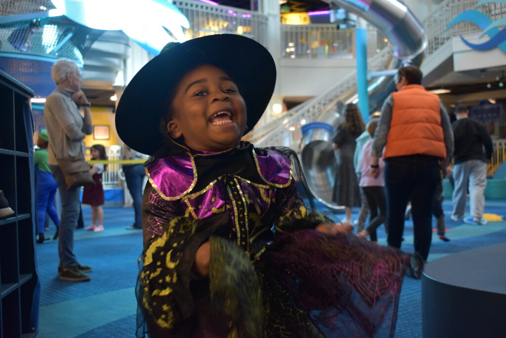 A little girl dressed as a witch laughing