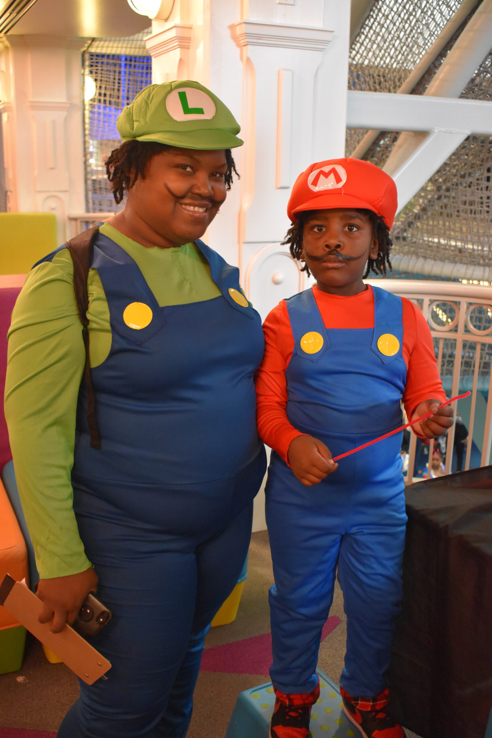 A mom and son are dressed as Luigi and Mario