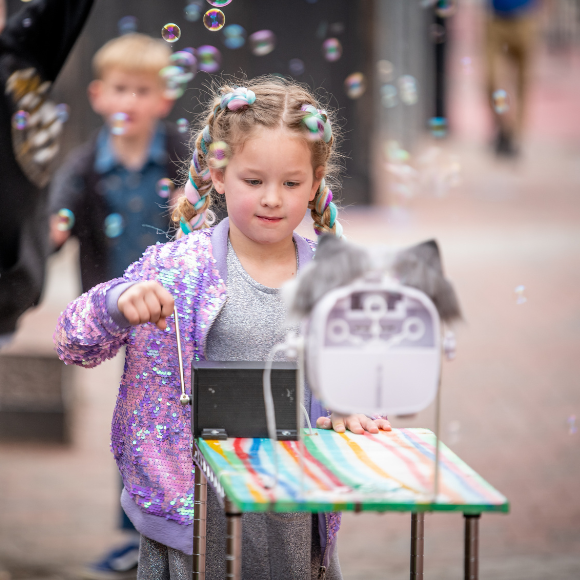 Girl uses a bubble machine at Port Discovery Children's Museum