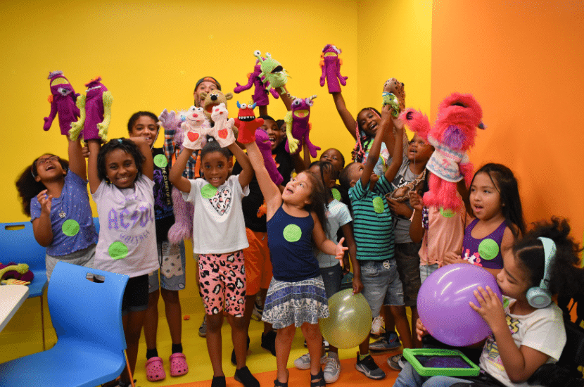 Children pose and cheer at Port Discovery Children's museum during a birthday party