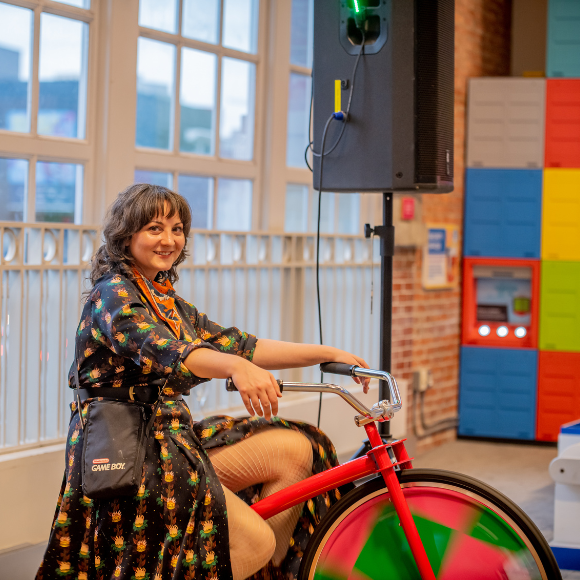 Woman rides colorful bike at Port Discovery Children's Museum