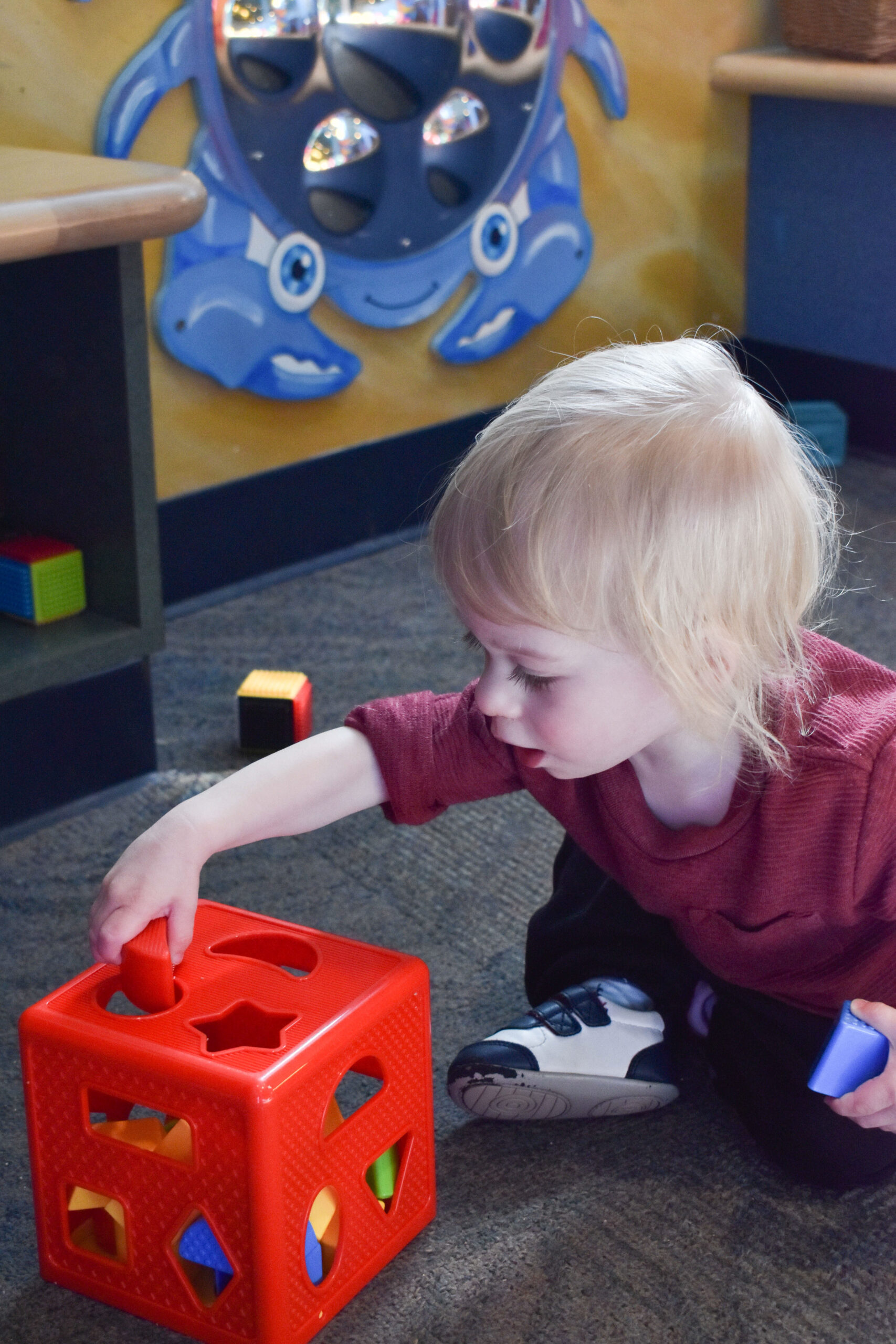 toddler boy playing with missing shape puzzle