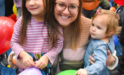a women with 2 girls holding balloons during new years